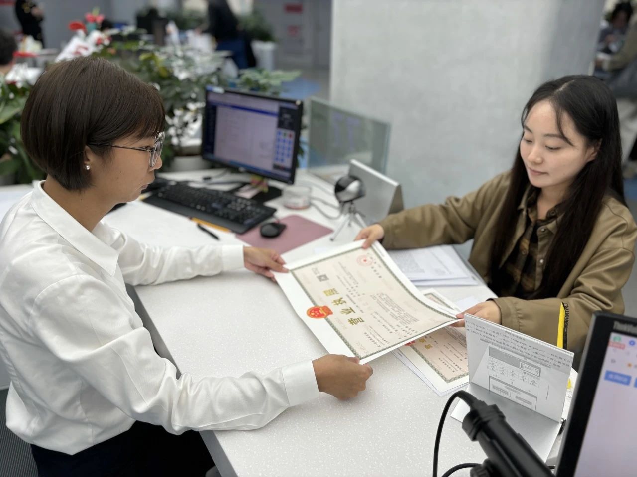 默克檢測(上海)有限公司的工作人員正在領(lǐng)取新的營(yíng)業(yè)執照